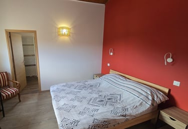 Chambre d'hôtes refaite à neuf avec lit double, chaise et bureau.