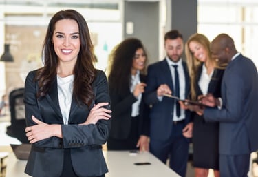 mujer en un traje parada al frente de un grupo de trabajo