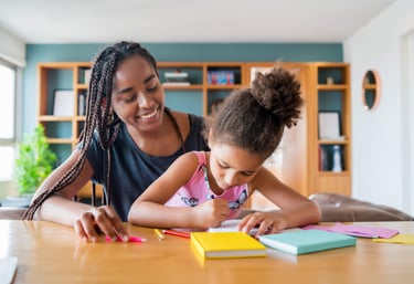 Une maman accompagnant sa fille dans l'exécution des devoirs à domicile. Tolanda, suivi scolaire