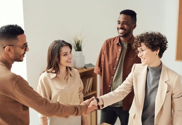 a group of people shaking hands with a woman in a suit