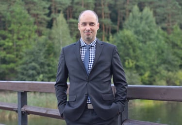 a man in a suit and tie standing on a bridge