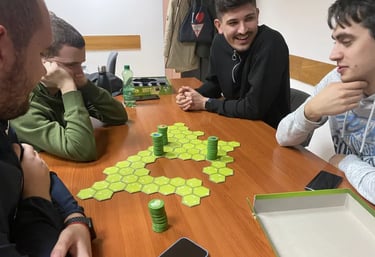 Grupa ljudi igra društvenu igru Battle Sheep, uživajući u strateškoj zabavi na stolu