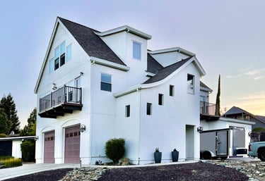 Corner perspective of a beautiful white French Revival architecture home.