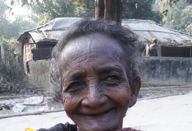 an old woman smiling and holding a blanket