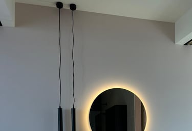 Moderne badkamer met een ronde LED-spiegel en een zwevende designwastafel.