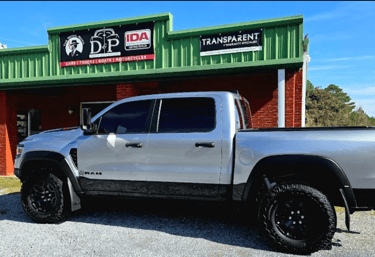 A truck, tinted in front of D and P auto detailing