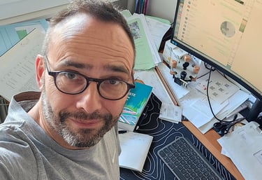 a man wearing glasses works on his computer