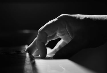 a person's hand is touching the keyboard of a piano