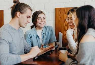 a group of people sitting at a table with a tablet