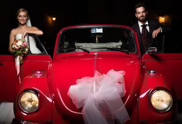 Sposi nel loro giorno da sogno che scattano una foto con il nostro splendido maggiolone d'epoca.