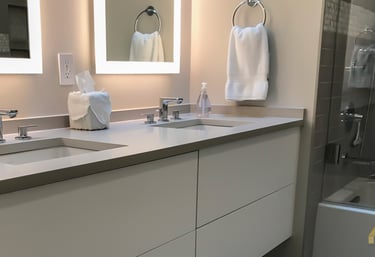 a bathroom with a large mirrors and wall hanging vanities