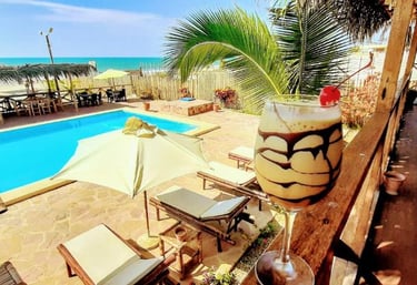 Una copa de cocktail en un balcón junto a la piscina