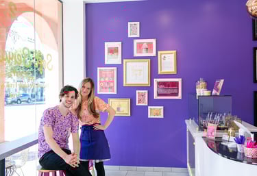 a man and woman standing in front of a purple wall