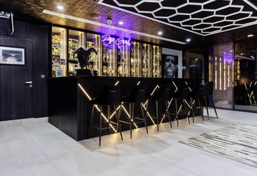 Chic indoor bar with black and gold accents and neon lighting.