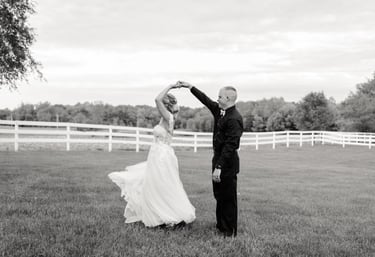 a bride and groom dancing in a field