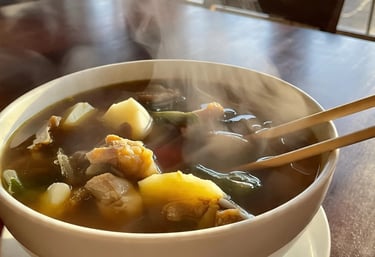 a bowl of bouillon soup with chopsticks and chopsticks