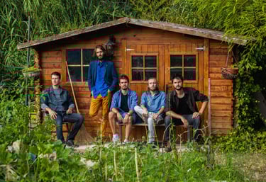 photographie d'un groupe de musiciens de rock devant un cabanon de jardin en pleine nature