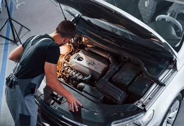 a man working on a car engine in a garage