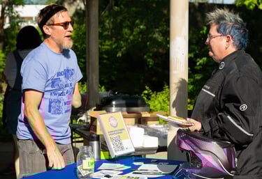 Two people talking over a table with printed resources on it