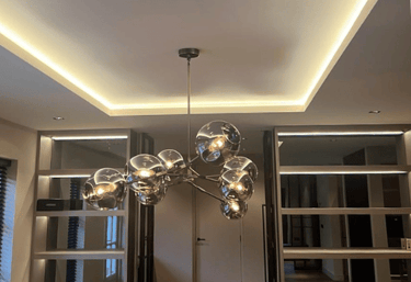 Moderne eetkamer met sfeervolle verlichting en luxe hanglamp, geïnstalleerd door M.W. Elektra Techniek.