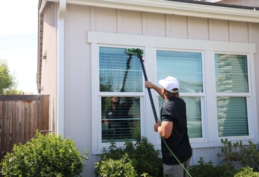 kyler using the waterfed pole to clean a windows frames, glass, and sills