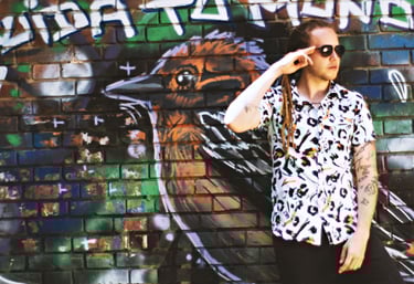 a man in a white shirt and sunglasses talking on a cell phone