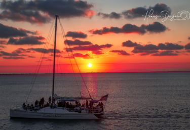 a sailboat in the ocean at sunset