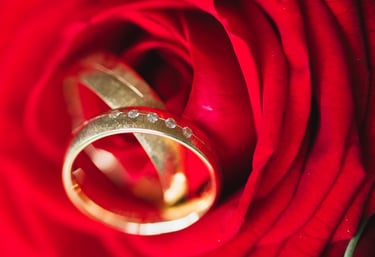 a wedding ring with a diamond ring on top of a rose