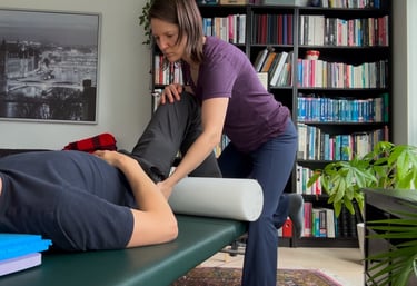 A Feldenkrais Teacher is giving a Functional Integration©️ session to a man.