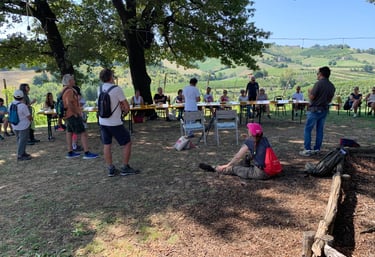 a group of people standing around a table with food