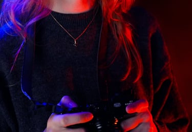 le portrait d'une femme qui tiens un appareil photo avec un jeu de lumière rouge et bleu
