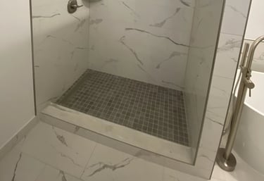 Contemporary walk-in shower with marble-look tiles and brushed nickel fixtures