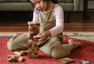 petite fille en train de construire une tour de cubes