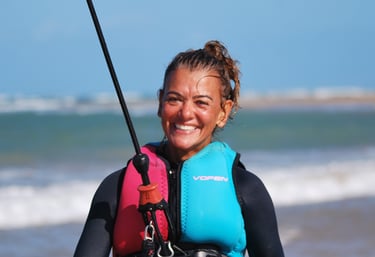 a woman in a wetsuit connecte a kitesurf