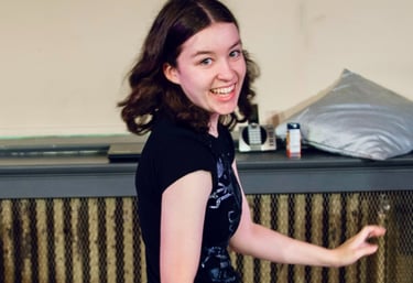 A preteen girl dances giddily as she spins to look at the camera