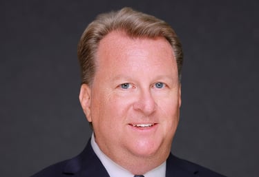 Business headshot of a man in a suit and tie