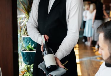 Waiter serving wine in upscale restaurant – hospitality brand experience