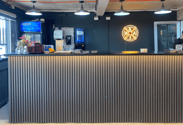 Diseño de barra de sushi listonada con iluminación técnica por Atípico Studio en Santiago.