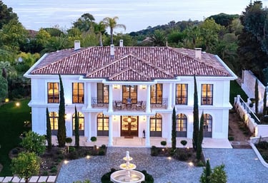 a large mansion with a fountain in the foreground
