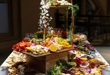 Large charcuterie display with fresh fruit, meats, cheese, crackers displaye on a large glass tiered