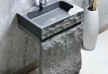 a stone sink with a stone sink and a vase with flowers