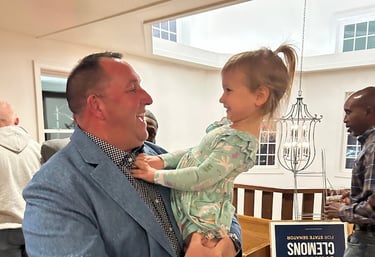 a man in a suit and tie is holding a baby