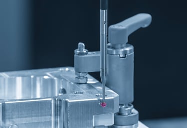 Image of machined part being inspected by CMM probe stylus. 