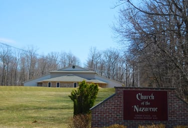 a church sign with a church in the background