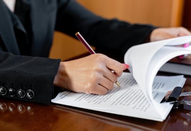 a woman in a suit revising and signing a document