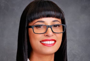 Headshot of a lady with glasses and a white jacket
