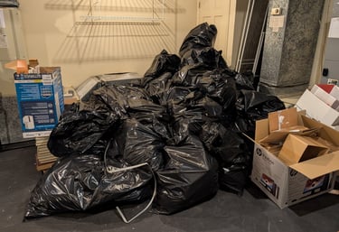 pile of trash bags and cardboard boxes
