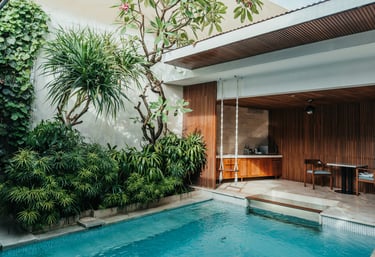 Luxury villa with a private pool on a tropical island, surrounded by lush greenery and scenic views.