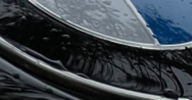 bmw logotipas ant automobilio variklio dangčio po to, kai jis buvo padengtas hidrofobiniu sluoksniu