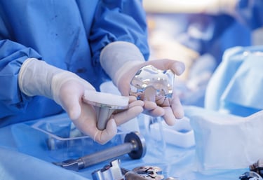 medical technical inspecting a set of orthopedic knee implants.